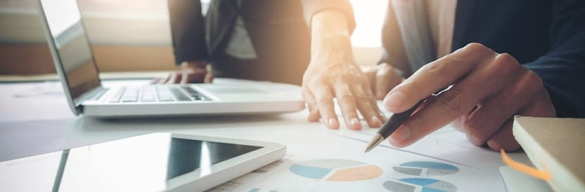 Hands pointing at graphs on desk